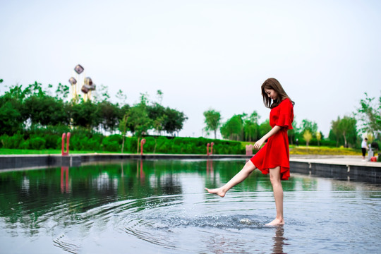 池塘里玩水的红衣女孩