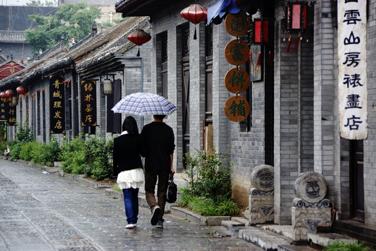 雨中古街打伞的一对恋人