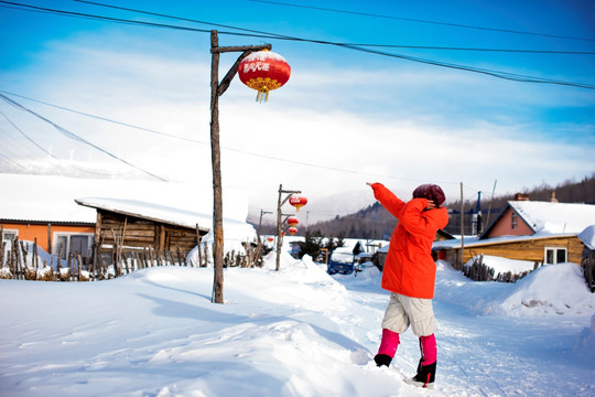 站在雪地村庄里的女人