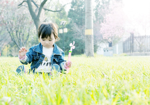 草地上吹泡泡的小孩子