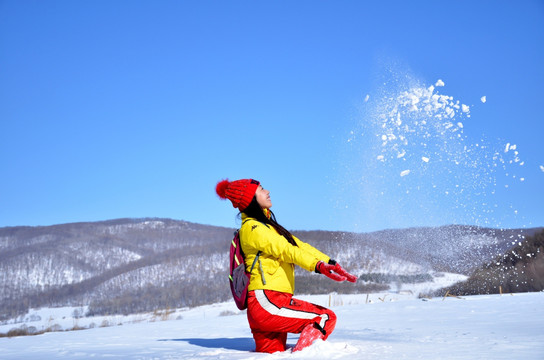 冬季在雪中扬雪的户外美女