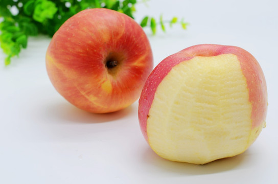 白色背景上削了一半皮的苹果