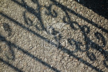 铁栅栏在水泥地上的投影
