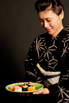 穿着日本服装的女人一盘寿司