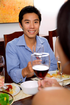 男人在餐桌上拿着酒杯