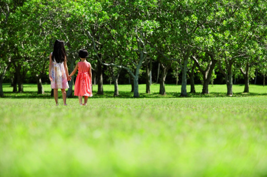 女孩手牵手在公园散步