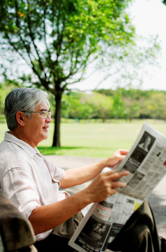 高级男子在公园看报纸