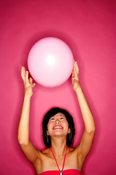 女子抛粉红色气球