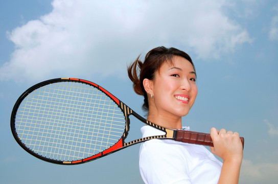 年轻女子拿着网球拍过肩
