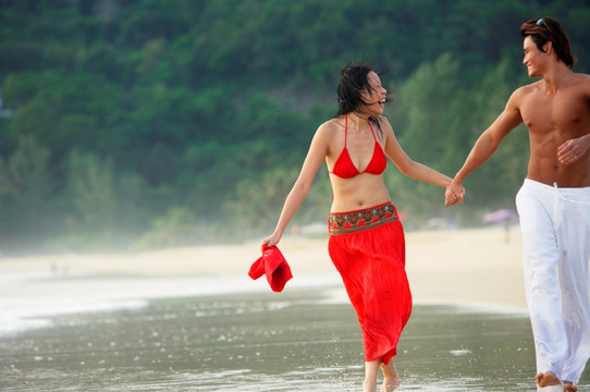 情侣沿着海滩跑步