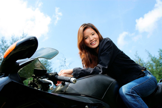 年轻女子坐在摩托车上