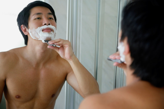男人看镜子剃须