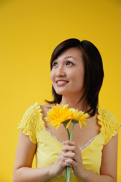 年轻女子抱着黄色的花朵