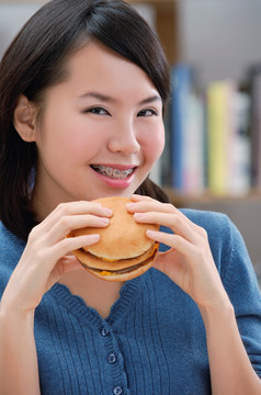 年轻的女人吃着汉堡包