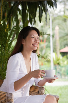 女人捧着杯子和茶托