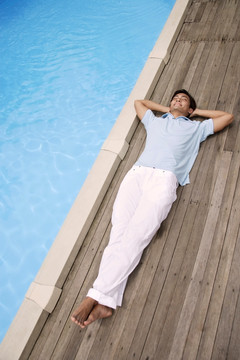 男子躺在游泳池