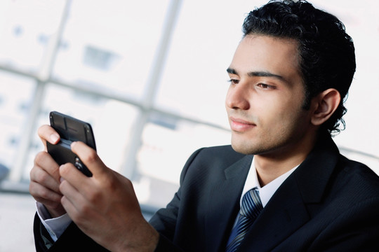 年轻商人使用手机短信