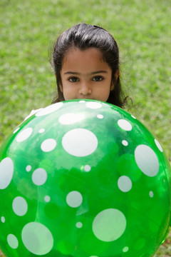 一个小女孩玩一个绿色的球
