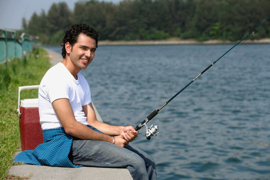 年轻人在河里钓鱼