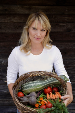 抱着一篮蔬菜的女人