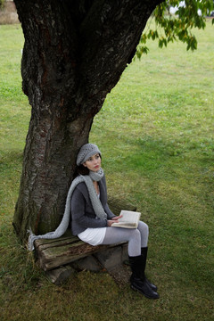 坐在树下看书的女人