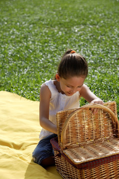 一个年轻的女孩打开野餐篮