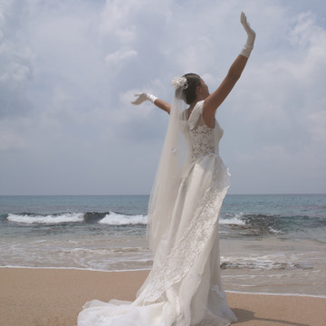 海滩上穿着婚纱的年轻女子