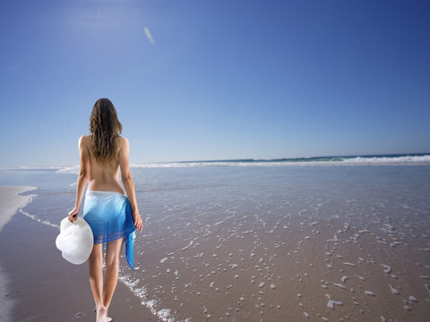 走在海边沙滩上的女人