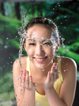 开心的年轻女人在洗脸