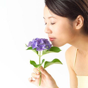 闭眼闻着鲜花味道的女人