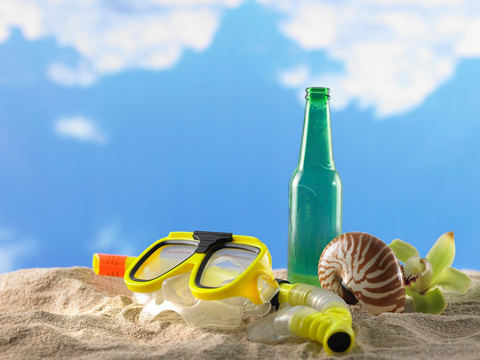沙滩上的浮潜用具和酒瓶