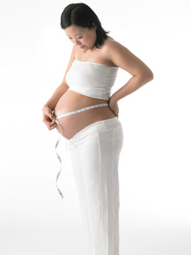 在测量腰围的孕妇