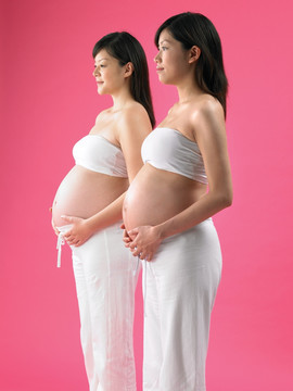 低头看着肚子的两名孕妇