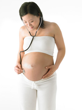 在用听诊器听胎儿心跳的孕妇