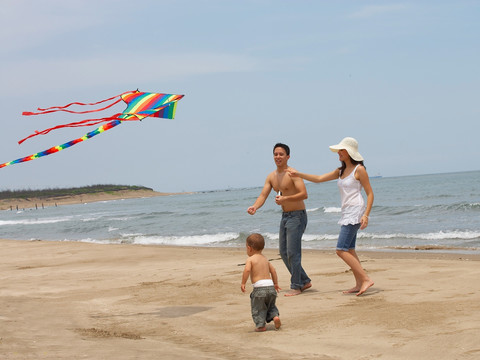 在海边放风筝的家人