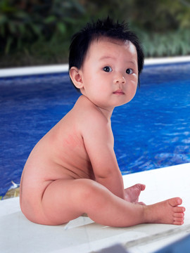 坐在泳池边的小婴儿
