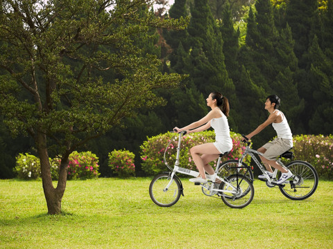 在草坪上骑自行车的夫妇