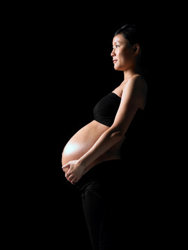 雙手放在肚子上的孕婦