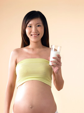 拿着一杯牛奶的孕妇