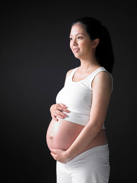 雙手放在肚子上的孕婦