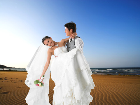 在海边抱起新娘的新郎