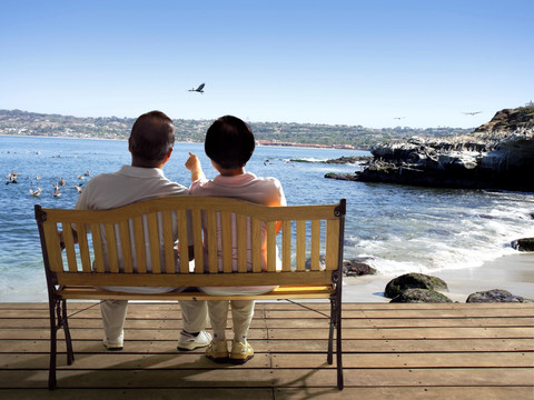 坐在长椅上看着大海的夫妇