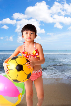 抱着沙滩足球的小女孩