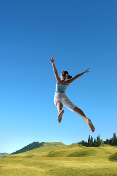 在草坪上跳跃的女人