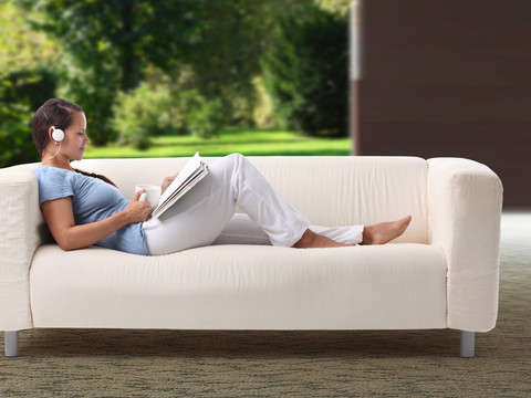 坐在沙发上看书听音乐的女人