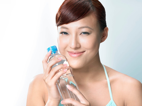 微笑的女人拿着一瓶水