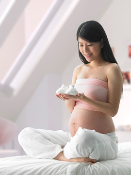 拿著一雙嬰兒鞋的孕婦