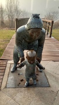 母亲扶小儿学步雕像
