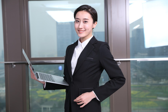 拿著筆記本電腦微笑著的女人