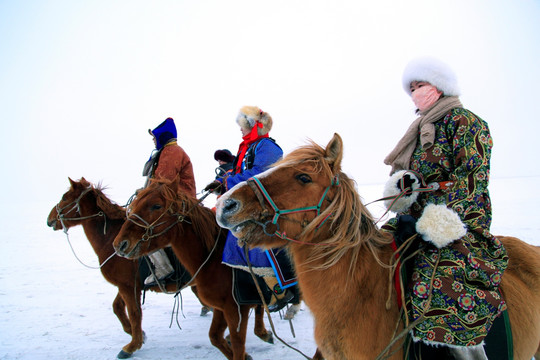 雪原骑马的蒙古族牧民
